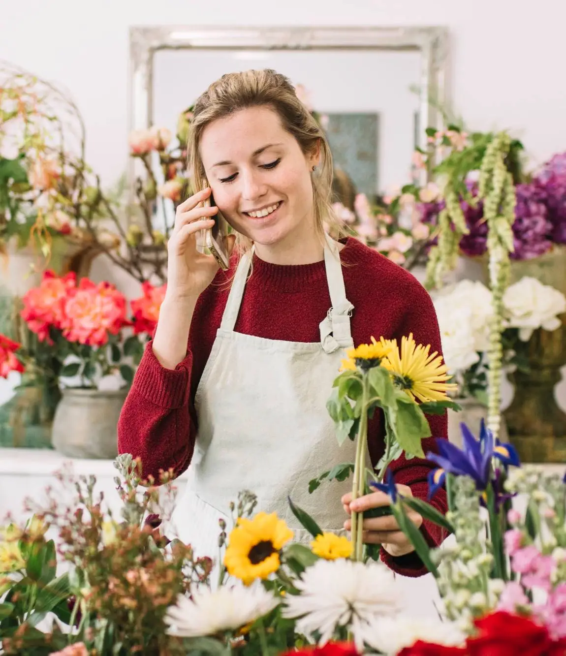 Woman speaking on smartphone in floral shop